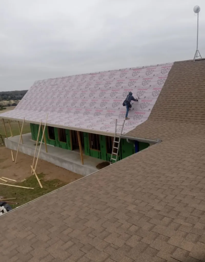 Worker preparing underlayment for a metal roof installation in Halifax